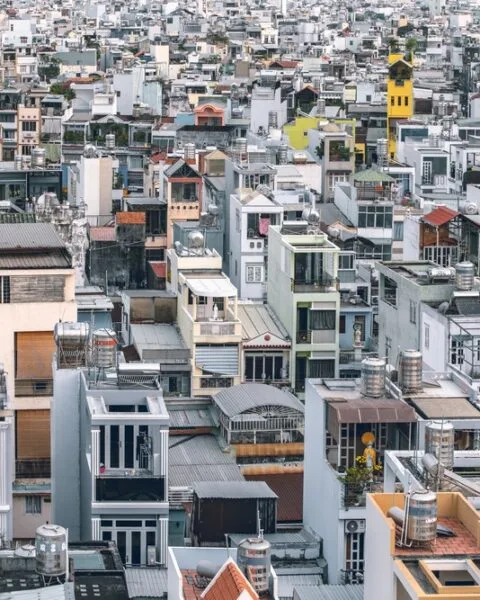 Dense urban landscape with tightly packed, variously colored buildings in Hochiminh, showing the crisis of Affordable Housing Vietnam.