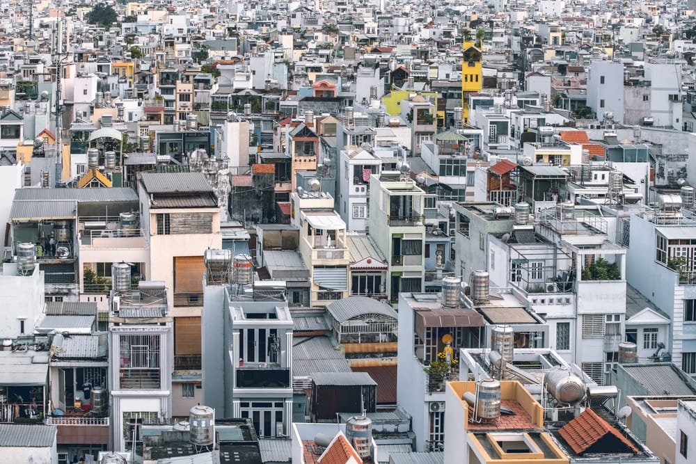 Dense urban landscape with tightly packed, variously colored buildings in Hochiminh, showing the crisis of Affordable Housing Vietnam.