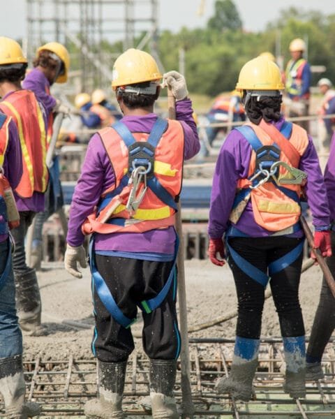 Construction workers in safety gear on a building site, symbolising Construction Labor Shortages Vietnam and the needs for more workers.